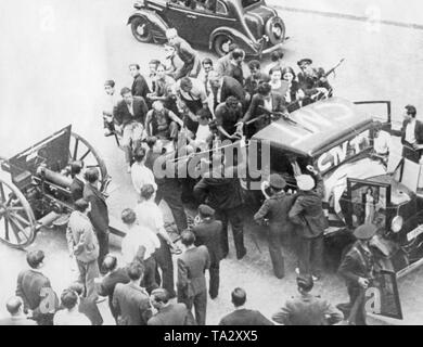 Un parzialmente unità armate dell'anarco-syndicalist spagnolo sindacato Confederacion Nacional del Trabajo (CNT, scritta sul carrello) e i civili stanno tentando di recuperare un cannone confiscati con un guinzaglio sulla strada di una città spagnola durante la Guerra Civile Spagnola. Sullo sfondo di un automobile. Dopo lo scoppio della guerra civile il 17 giugno 1936, molte città della Spagna sono state teatro di combattimenti di strada tra i repubblicani, i comunisti e i nazionalisti. Foto Stock