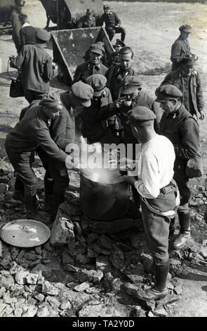 Membri del Volontariato Servizio del lavoro servire una tazza di caffè da una pentola. Foto Stock