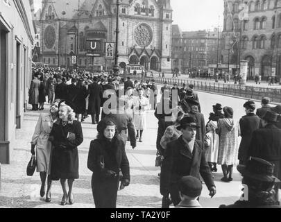 I passanti a piedi attraverso la Hardenbergstrasse a Berlino a Pasqua. Sullo sfondo la Kaiser Wilhelm Memorial Church. Foto Stock