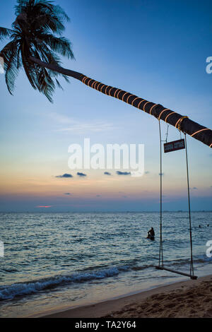 Swing su un albero di palma. Mare spiaggia al tramonto. Spa romanticismo, Phu Quoc island, Vietnam Foto Stock