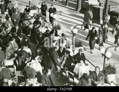 Il primo Café Kranzler a Berlino è stato aperto nel 1825 da Johann Georg Kranzler come una piccola pasticceria in strada "Unter den Linden" nel distretto Mitte di Berlino. Nel 1932 aprì il secondo ramo dell'ex Café des Westens sotto il nome di 'Restaurant und Konditorei Kranzler' in la Joachimstaler Strasse (oggi Joachimsthaler Strasse) nel quartiere Charlottenburg. Entrambi gli edifici sono stati distrutti durante i raid aerei negli anni 1944 e 1945. La foto mostra la strada terrazza, il cosiddetto "rampe", con alcuni ospiti. Foto Stock