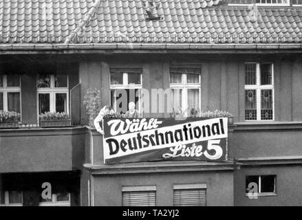 Durante la campagna elettorale delle elezioni del Reichstag nel 1932, i residenti locali di montare un cartellone elettorale della nazionale tedesca del partito popolare. Foto Stock