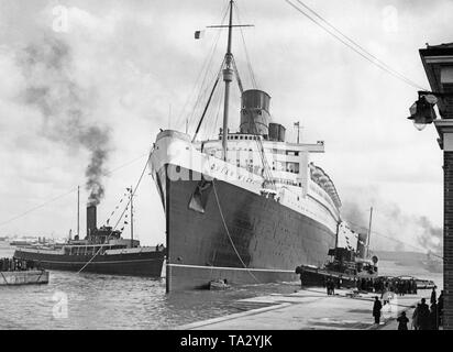 La Cunard ocean liner "Queen Mary' viene trainato dal cantiere in Scozia a Southampton per la pulizia della carena in 'King George V Graving Dock" dopo il suo primo viaggio. Foto Stock