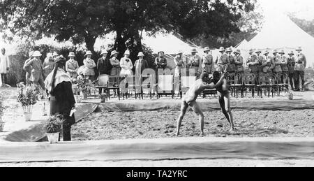 Il tedesco Principe Ereditario (in medio, in conversazione, una frusta in mano) accompagnata da alcuni funzionari dell'inglese amministrazione coloniale, guarda a un Indiano match wrestling. Foto Stock