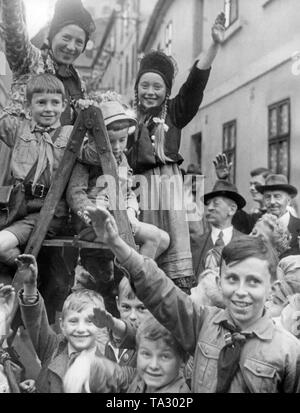 Un gruppo di bambini riceve Adolf Hitler allegramente in come il 3 ottobre 1938, durante l'occupazione dei Sudeti dalla Germania. I bambini sono saliti su una scala per ottenere una vista migliore. Foto Stock