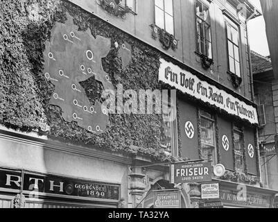 Nel corso dell'Anschluss (annessione) dell'Austria per il Reich tedesco, nazista del dittatore Adolf Hitler visite Graz. Le strade vengono decorate con bandiere con la svastica. Su una parete, una mappa della maggiore Reich germanico. Sul poster: "un popolo, una Reich, uno Fuehrer'. Foto Stock
