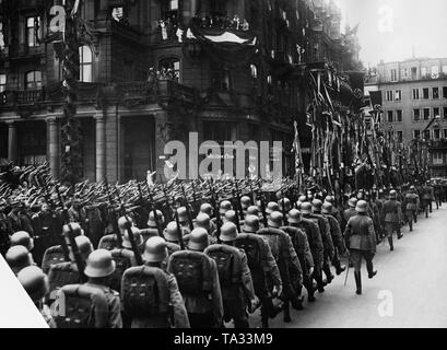 Scene of a military parade in front of the Dom-Hotel in Cologne from 29.3.1936 after the occupation and remilitarization of the Rhineland by Germany. In the middle, Wehrmacht soldiers. Further ahead in the train the flags of the Rheinisches Regiments. Left, a Thomas Cook travel agency. On the lower balcony of the Dom-Hotel: from left:  Werner von Fritsch, Robert Ley, Adolf Hitler and Werner von Blomberg. Foto Stock