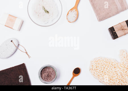 Lay piatto telaio di oggetti e prodotti cosmetici per il bagno su sfondo bianco con lo spazio vuoto al centro. Foto Stock