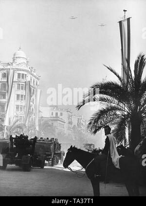 Foto di una parata di vittoria della nazionale spagnola di unità in Passeig de Colon dopo la conquista (gennaio 1939) di Barcellona dal generale Francisco Franco in febbraio, 1939. Un'artiglieria tedesca processione della Legione Condor è di passaggio. Il FLAK 8,8 cm 36 (due sul supporto assale) è portato da un pesante a mezza via veicolo, tipo 8 e 9. Nel cielo, formazione di volo il tedesco della Legione Condor. Foto Stock