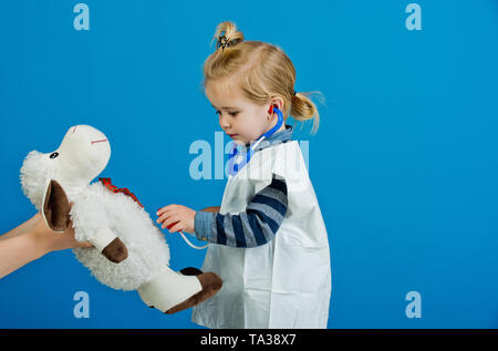 Bambino veterinario esamina toy animale con uno stetoscopio Foto Stock