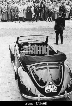 Un uomo SS custodisce un Maggiolino Cabrio a sua presentazione durante un evento di propaganda a Berlino. Foto Stock