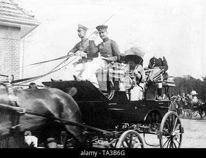 Il Principe e la principessa rigido per la gara di apertura con un quattro-in-trasporto a mano. Nella parte anteriore della scatola di pullman sit principe ereditario Wilhelm (l) e suo fratello August Wilhelm (r). Nella parte posteriore della vettura sono le due mogli Crown Princess Cecilie (sinistra), nato Duchessa di Mecklenburg e la Principessa Alexandra Viktoria (a destra), nato Duchessa di Schleswig-Holstein-Sonderburg-Gluecksburg. Foto Stock