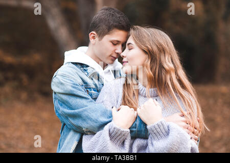 Amore teenage giovane azienda ogni altro all'esterno. Felice insieme. 20s. Foto Stock