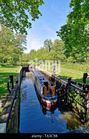 Una barca stretta passando attraverso Newark bloccare sul fiume Wey Navigation vicino a Ripley Surrey in Inghilterra REGNO UNITO Foto Stock