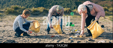 Volontari senior di pulizia della spiaggia Foto Stock