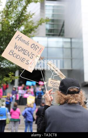 Donna che mantiene un appendiabiti segno a una protesta contro il divieto di aborto, Eugene, Oregon, Stati Uniti d'America. Foto Stock