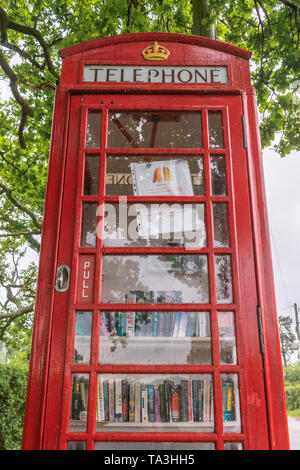 Red vecchia cabina telefonica che è stato convertito in una libreria in un giorno di pioggia in Fritham, New Forest, England, Regno Unito Foto Stock