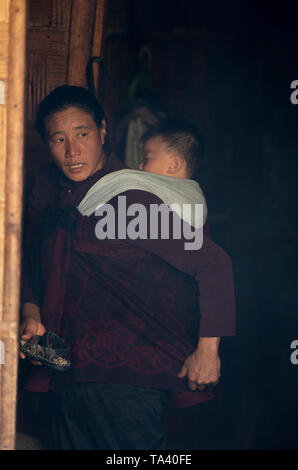 Madre con un giovane bambino su il suo ritorno al villaggio Khonoma il 4 Dic 2016 al villaggio Khonoma,nagaland Foto Stock
