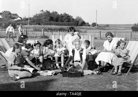 Elsie Cooper, il matron da wind-up gramophone a Gracie Field Orphanage a Peacehaven, Sussex con bambini, alla fine degli anni '50 o all'inizio degli anni '60 Foto Stock