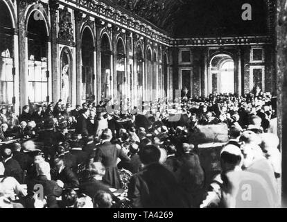 Il Ministro degli esteri tedesco Hermann Mueller e il ministro dei Trasporti Johannes Bell firmano il Trattato di Versailles. Centinaia di persone sono presenti nella Sala Specchi di Versailles. L'Assemblea nazionale tedesca ha autorizzato il governo a firmare solo dopo settimane di lotta. Foto Stock