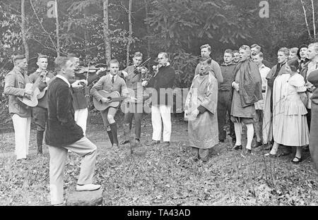 Gli studenti di un campo di lavoro per trascorrere la serata insieme, essi intrattenersi con musica e spettacoli teatrali in una foresta. Foto Stock