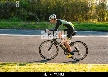 Racing in posizione aero in TT su time trial club evento in serata estiva che conduce fino a Brands Hatch Foto Stock