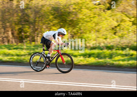 Racing in posizione aero in TT su time trial club evento in serata estiva che conduce fino a Brands Hatch Foto Stock