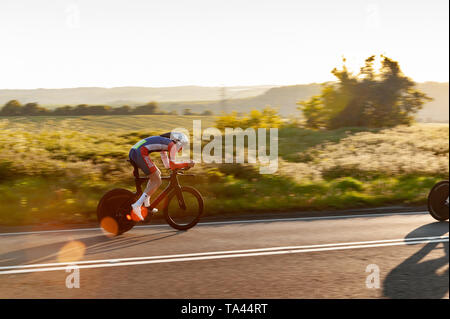 Racing in posizione aero in TT su time trial club evento in serata estiva che conduce fino a Brands Hatch Foto Stock