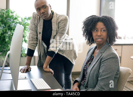 Il nero americano africano imprenditrici o i colleghi di lavoro insieme in un ufficio a fare gioco di squadra o il lavoro di formazione. Le donne stanno lavorando insieme a un avvio b Foto Stock