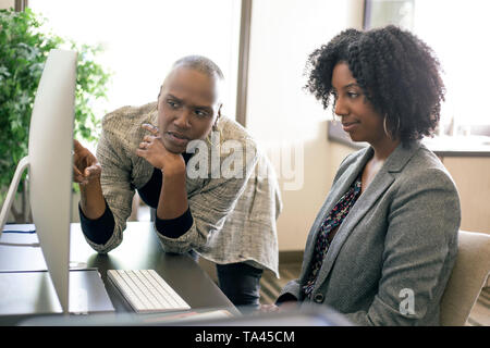 Africano nero donna americana co-lavoratori avente un problema aziendale e irritati o turbare gli uni gli altri. La mancanza delle donne il lavoro di squadra o commesso un errore a w Foto Stock
