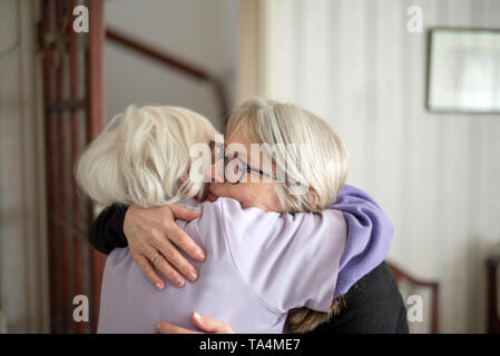 La madre non vuole che sua figlia a lasciare dopo una visita per vedere la sua anziani e non vedenti madre,la figlia abbracci e dice addio a sua mamma, b Foto Stock