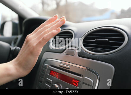 Donna verifica funzionamento del condizionatore in auto, primo piano Foto Stock