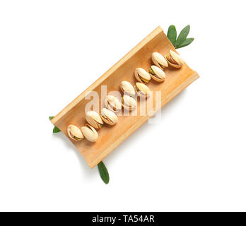 Supporto di bambù con gustosi pistacchi su sfondo bianco Foto Stock