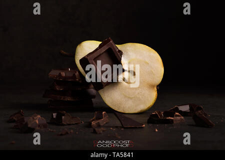 Pera e cioccolato su sfondo di legno, stato d'animo scuro Foto Stock