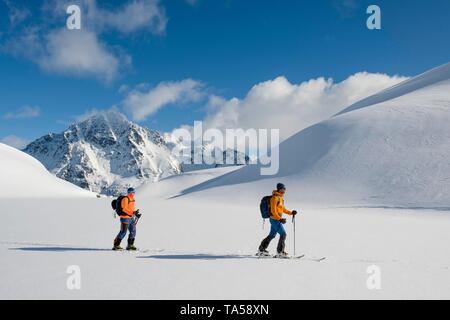 Chi pratica lo sci alpinismo sul banco di Pilan, Austvagoy, Lofoten, Norvegia Foto Stock