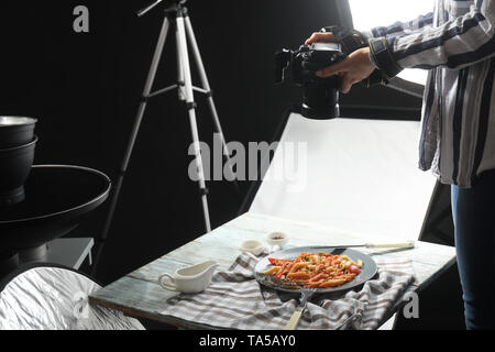 Giovane donna sta immagine di gustosi piatti di pasta in professional photo studio Foto Stock