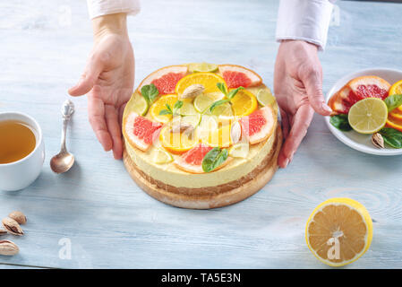 Materie torta agli agrumi con succo di pompelmo, arancio, lime e limone con dadi e menta. Cottura a casa sano estate vegan dessert Foto Stock