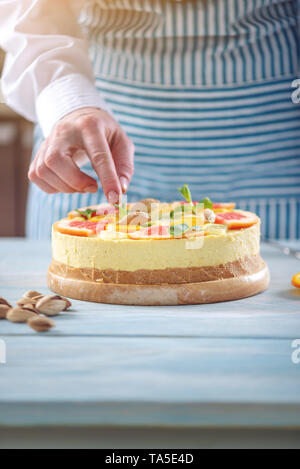 Materie torta agli agrumi con succo di pompelmo, arancio, lime e limone con dadi e menta. Cottura a casa sano estate vegan dessert Foto Stock