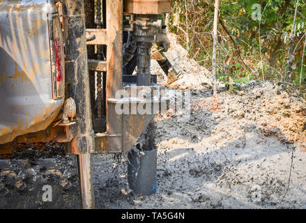 Acque sotterranee di foratura / scavo foro delle acque sotterranee macchina perforatrice installato su deeps terra e fango - messa a fuoco selettiva Foto Stock