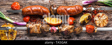 Assortimento di piatti alla griglia, spiedini, salsicce e verdure grigliate Foto Stock