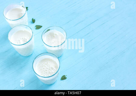 Ayran, yogurt fatto in casa bevanda (kefir, lassi) con cetrioli - estate sani rinfrescanti drink freddo sul blu, copia dello spazio. Foto Stock