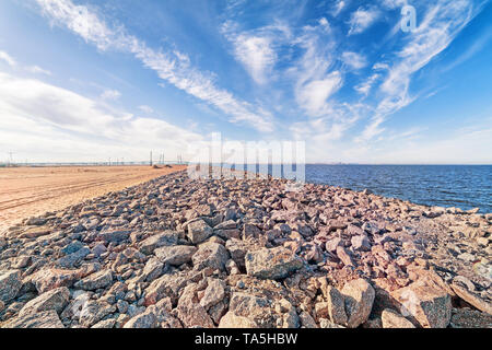 Ampio angolo di mare paesaggio industriale con skyline, sabbia, sky pietre e ponte distanti a San Pietroburgo, Russia Foto Stock