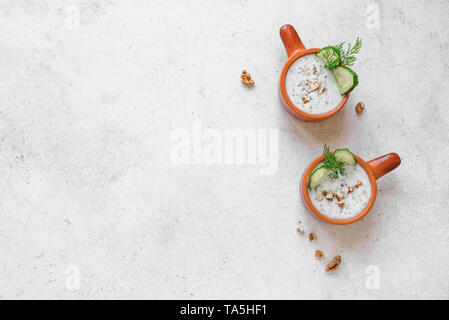 Tarator - cucina bulgara. Estate zuppa fredda con yogurt, erbe, noci e cetriolo per una sana dieta, vista dall'alto, copia dello spazio. Foto Stock