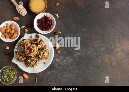 Morsi di energia con i dadi, cacao, semi di mirtilli rossi secchi e miele - vegetariano vegano materie organiche di muesli snack morsi su sfondo scuro, copia dello spazio. Foto Stock