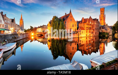 Canal a Bruges e la famosa torre campanaria sullo sfondo al tramonto, notte, Belgio Foto Stock
