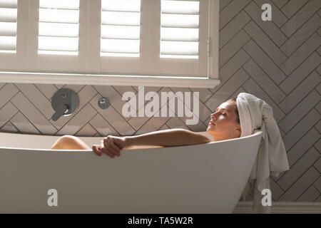 Bella donna di relax nella vasca da bagno Foto Stock