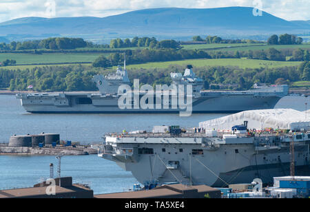 Rosyth, Scotland, Regno Unito. 22 Maggio, 2019. Portaerei HMS Queen Elizabeth ormeggiato a Rosyth nel fiume Forth dopo aver lasciato il bacino di carenaggio ieri dopo una visita a casa sua porta. Lei lascerà il via oggi e tornare al mare in preparazione per Westlant 19 deployment che è progettato per concentrarsi sulle operazioni del suo F-35 degli aerei da caccia. Nella foto; rara vista sia della Royal Navy di portaerei. HMS Queen Elizabeth sulla sinistra e HMS Prince of Wales ancora in costruzione nel cantiere di Rosyth. Credito: Iain Masterton/Alamy Live News Foto Stock