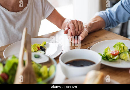 Una sezione mediana della coppia senior in amore al chiuso in casa, avente il pranzo. Foto Stock