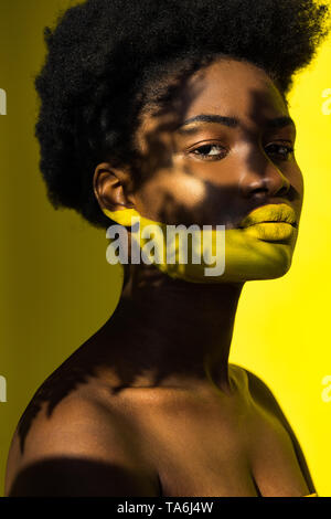 Bella americano africano donna con body art su giallo Foto Stock