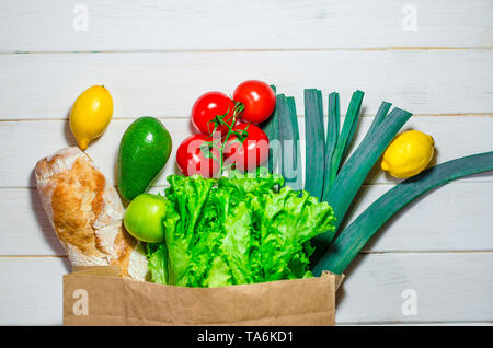 Sacchetto di carta di diversa della salute alimentare su bianco sullo sfondo di legno. Vista superiore Foto Stock